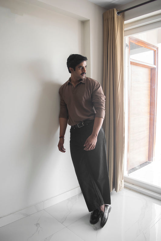 Man standing confidently wearing a brown long sleeve oversized polo shirt, exuding casual elegance and style