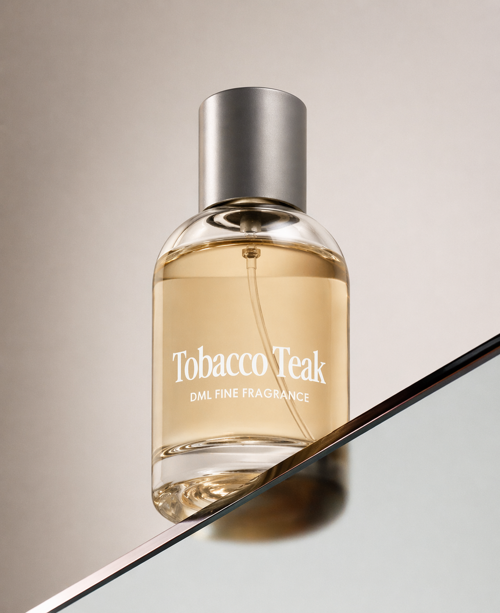 Perfume bottle labeled 'Tobacco Teak' on a reflective surface with a neutral background